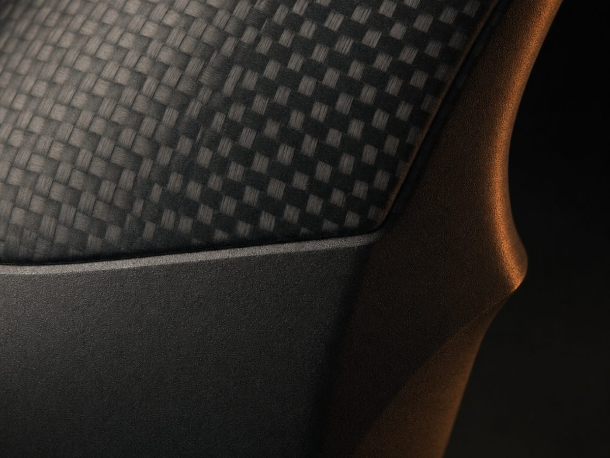 Close detail of the machined seam where a carbon composite shell meets a matte grip.