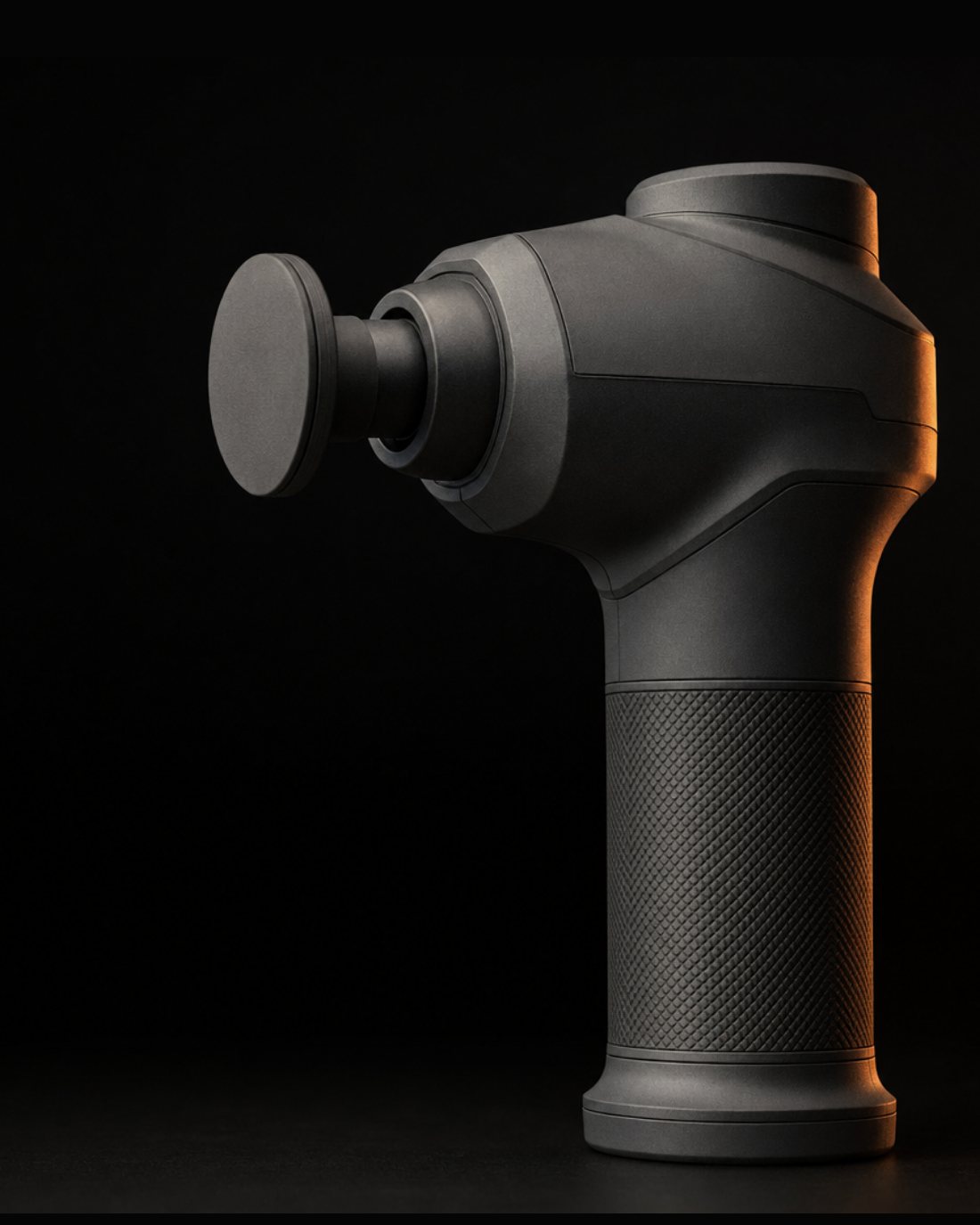 A matte graphite Vigora percussion tool, three quarter view, lit against a dark background.
